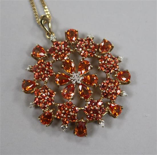 A 9ct gold, orange sapphire? and diamond set pendant, on a 9ct gold fine link chain, pendant 39mm.